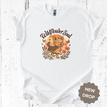 White t-shirt with a dog graphic and 'Wildflower Soul' text on a wooden surface.