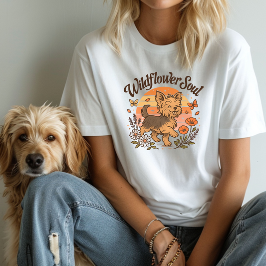 Person wearing a white t-shirt with a dog graphic and 'Wildflower Soul' text, sitting next to a dog.