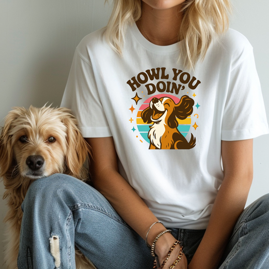 Person wearing a white t-shirt with a dog graphic and text, sitting next to a dog.