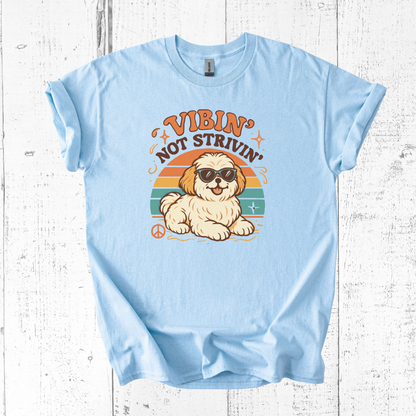 Light blue t-shirt with a dog graphic and text on a wooden surface