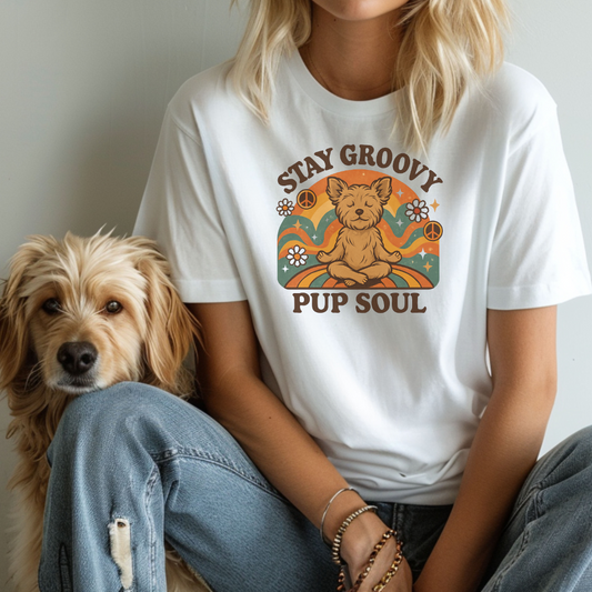 Person wearing a white t-shirt with a graphic design and text, sitting next to a dog.