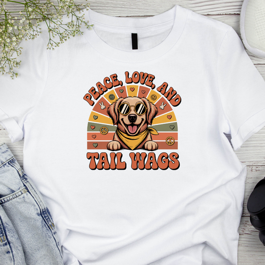 White t-shirt with a dog graphic and 'Peace, Love, and Tail Wags' text on a wooden surface.