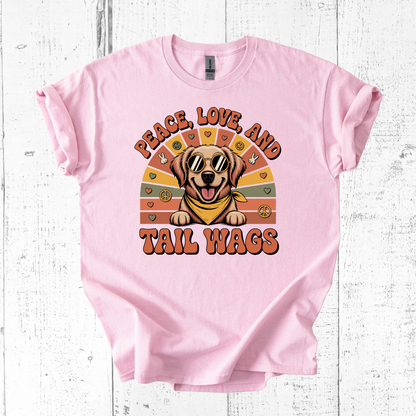 Pink t-shirt with a dog graphic and 'Peace, Love, and Tail Wags' text on a wooden surface