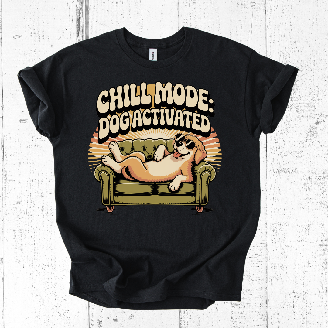 Black t-shirt with a graphic of a dog on a couch and text 'Chill Mode: Dog Activated' on a white wooden background.