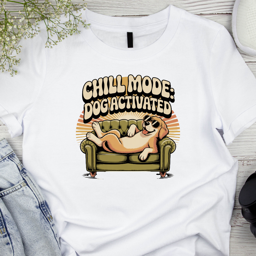 White t-shirt with a dog graphic and 'Chill Mode: Dogiactivated' text on a wooden surface and the phrase Chill Mode: Dog Activated