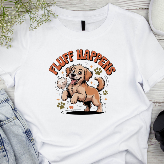 White t-shirt with a cartoon dog and 'Fluff Happens' text on a wooden surface.
