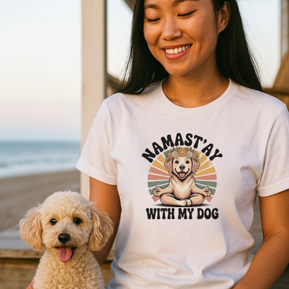 Woman wearing a white t-shirt with a dog graphic and text, sitting on a beach.