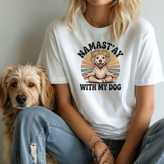 Person wearing a white t-shirt with a dog graphic and text, sitting next to a dog.