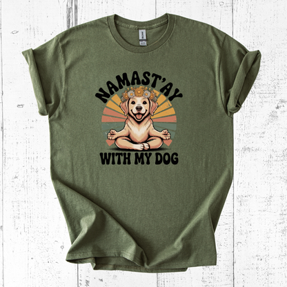 Green t-shirt with a dog graphic and text 'Namast'ay with my dog' on a white wooden background