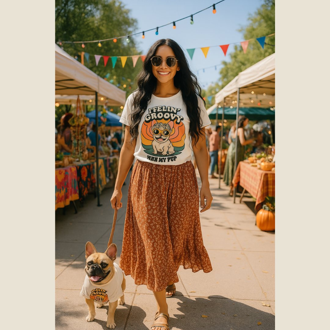 Woman walking a dog at an outdoor market wearing a 'Groovy' t-shirt.