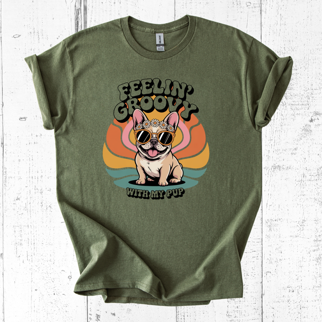 Green t-shirt with a dog graphic and 'Feelin' Groovy with my pup' text on a white wooden background