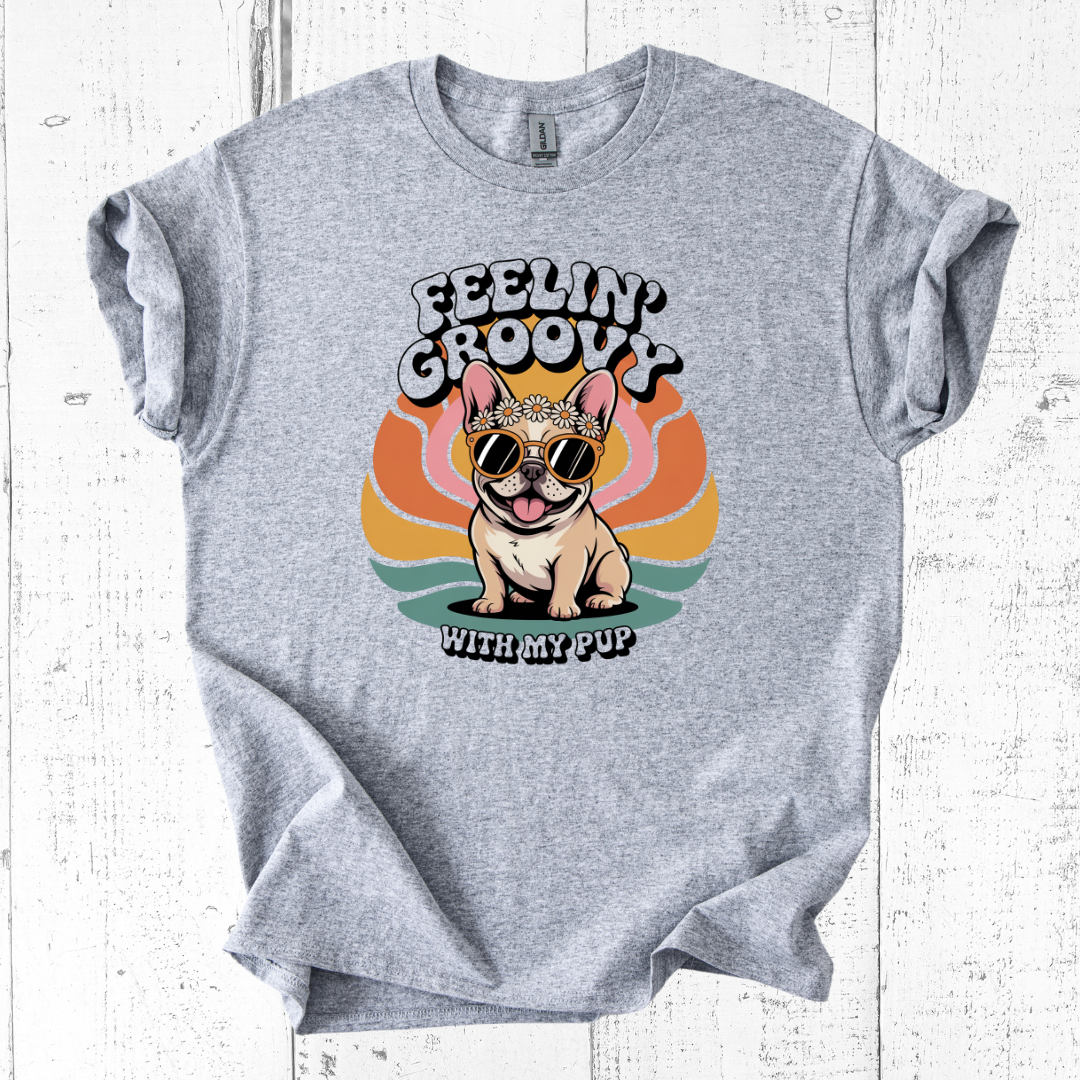 Gray t-shirt with a dog graphic and 'Feelin' Groovy with my pup' text on a white wooden background