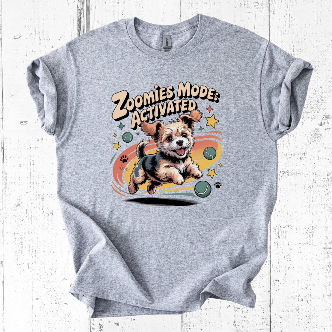 Gray t-shirt with a dog graphic and 'Zoomies Mode Activated' text on a white wooden background