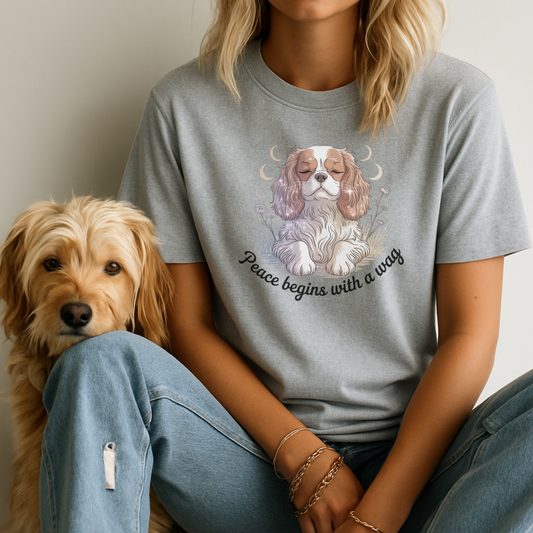 Person wearing a gray t-shirt with a dog illustration and text, sitting next to a dog.