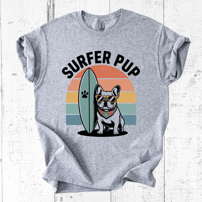 Gray t-shirt with 'Surfer Pup' design featuring a dog with sunglasses and a surfboard on a white wooden background.