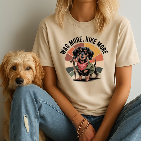 Person wearing a t-shirt with a dog graphic and text, sitting next to a dog.
