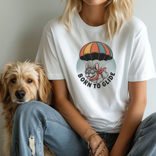 Person wearing a white t-shirt with a dog graphic and 'Born to Glide' text, sitting next to a dog.
