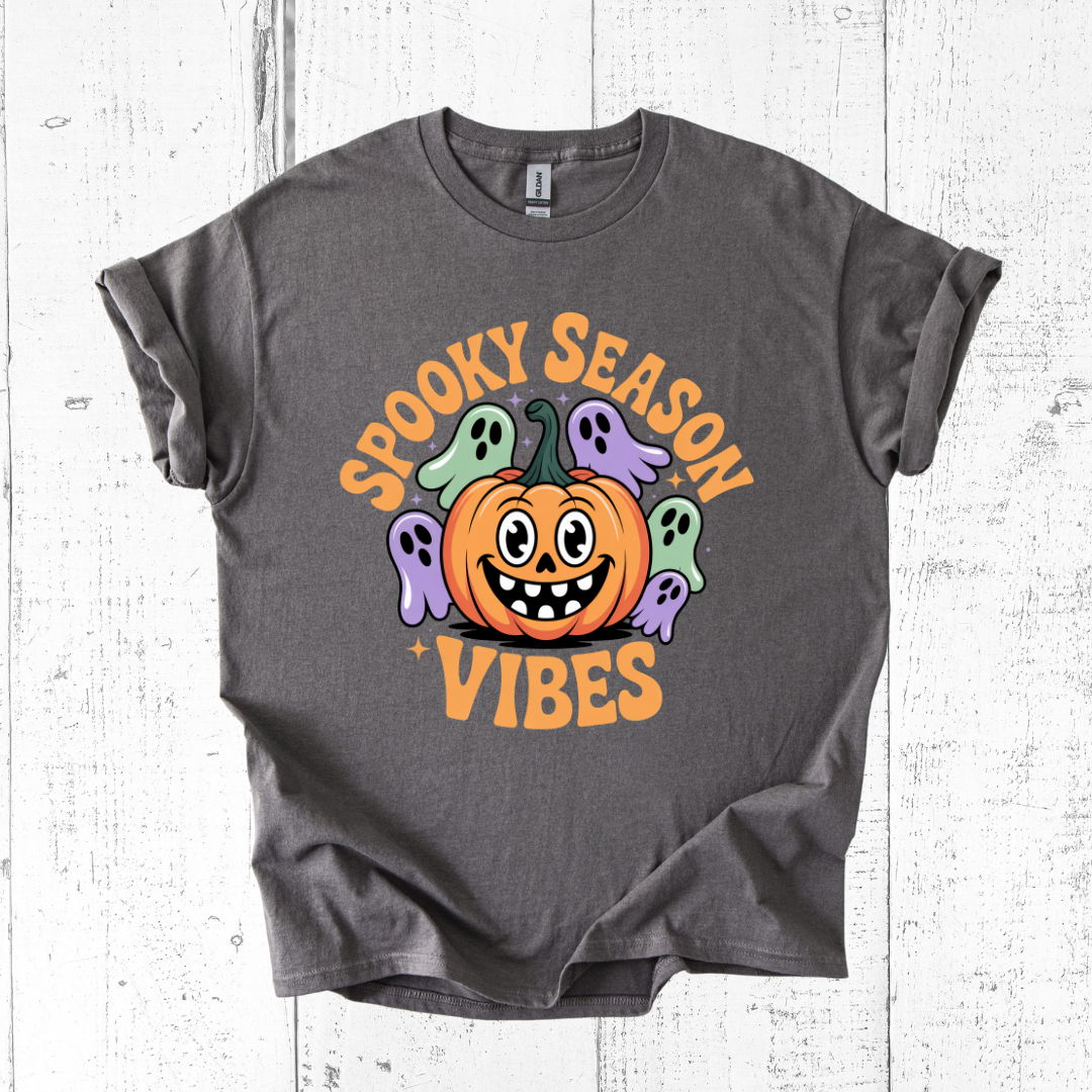 Gray t-shirt with Halloween-themed design featuring a pumpkin and ghosts on a white wooden background.