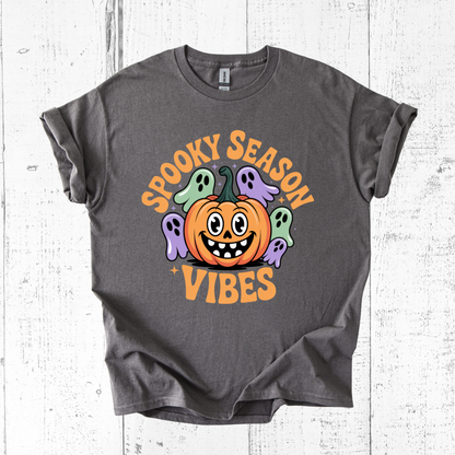 Gray t-shirt with Halloween-themed design featuring a pumpkin and ghosts on a white wooden background.