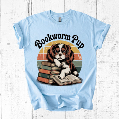 Light blue t-shirt with a dog graphic and 'Bookworm Pup' text on a wooden surface