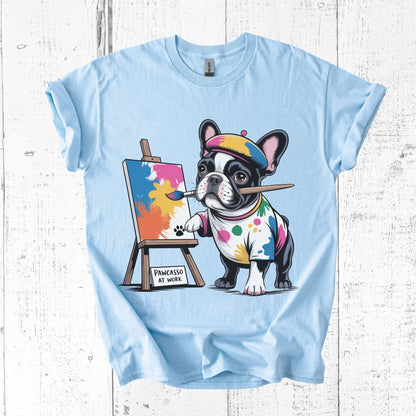 Light blue t-shirt with a cartoon dog painting design on a white wooden background