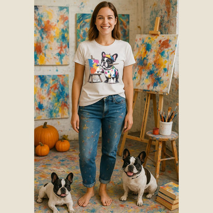 Woman wearing a t-shirt with a dog graphic in an art studio with two dogs.