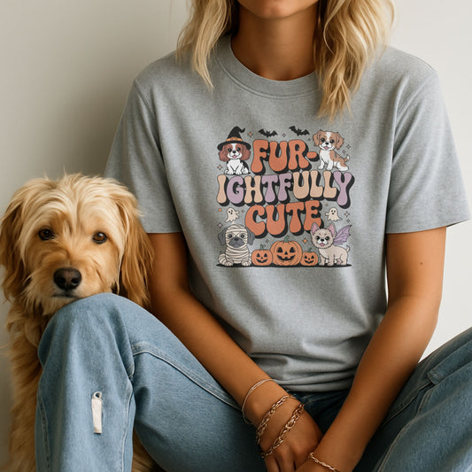 Person wearing a gray t-shirt with a dog-themed design, sitting next to a dog.