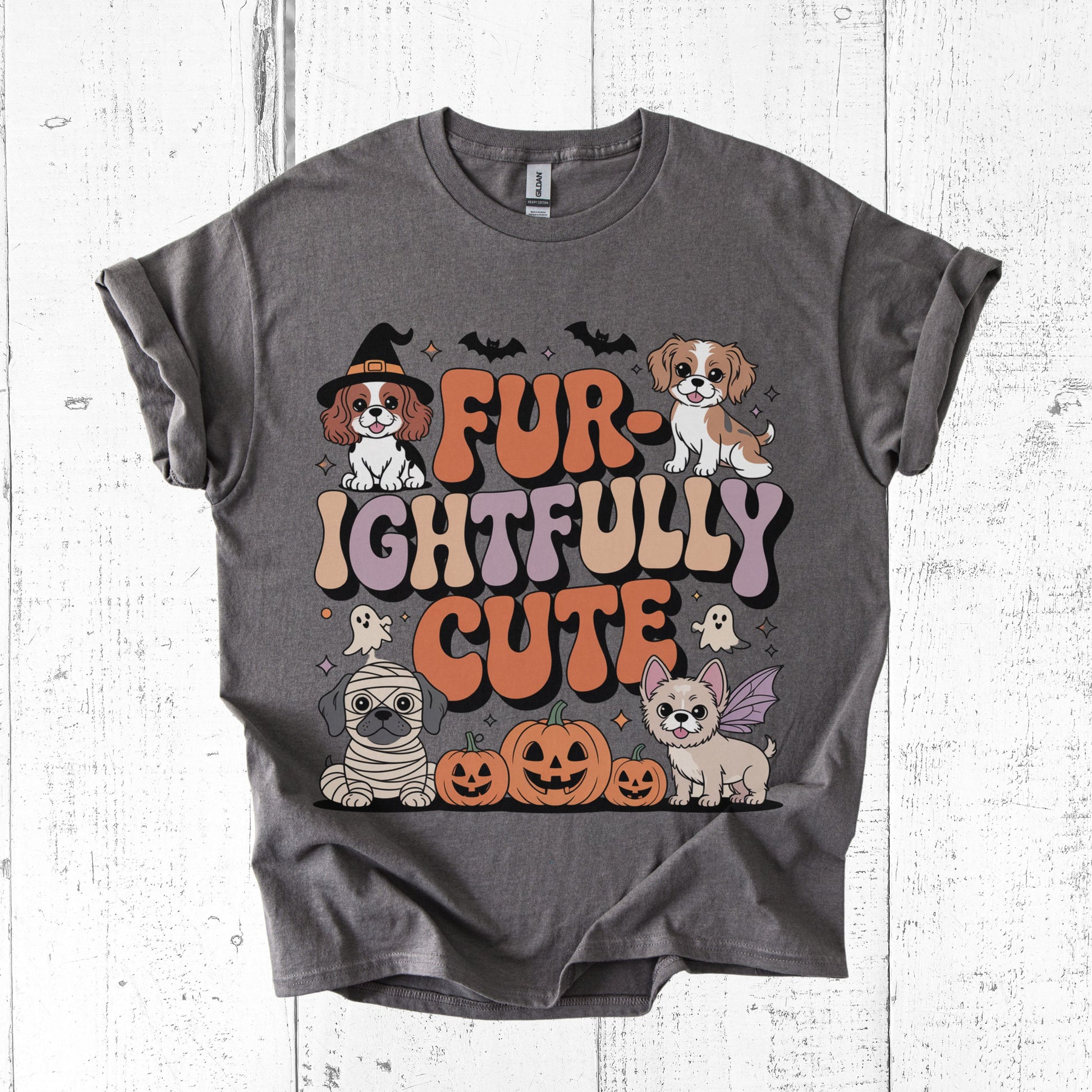 Gray t-shirt with Halloween-themed graphic of dogs and text on a white wooden background