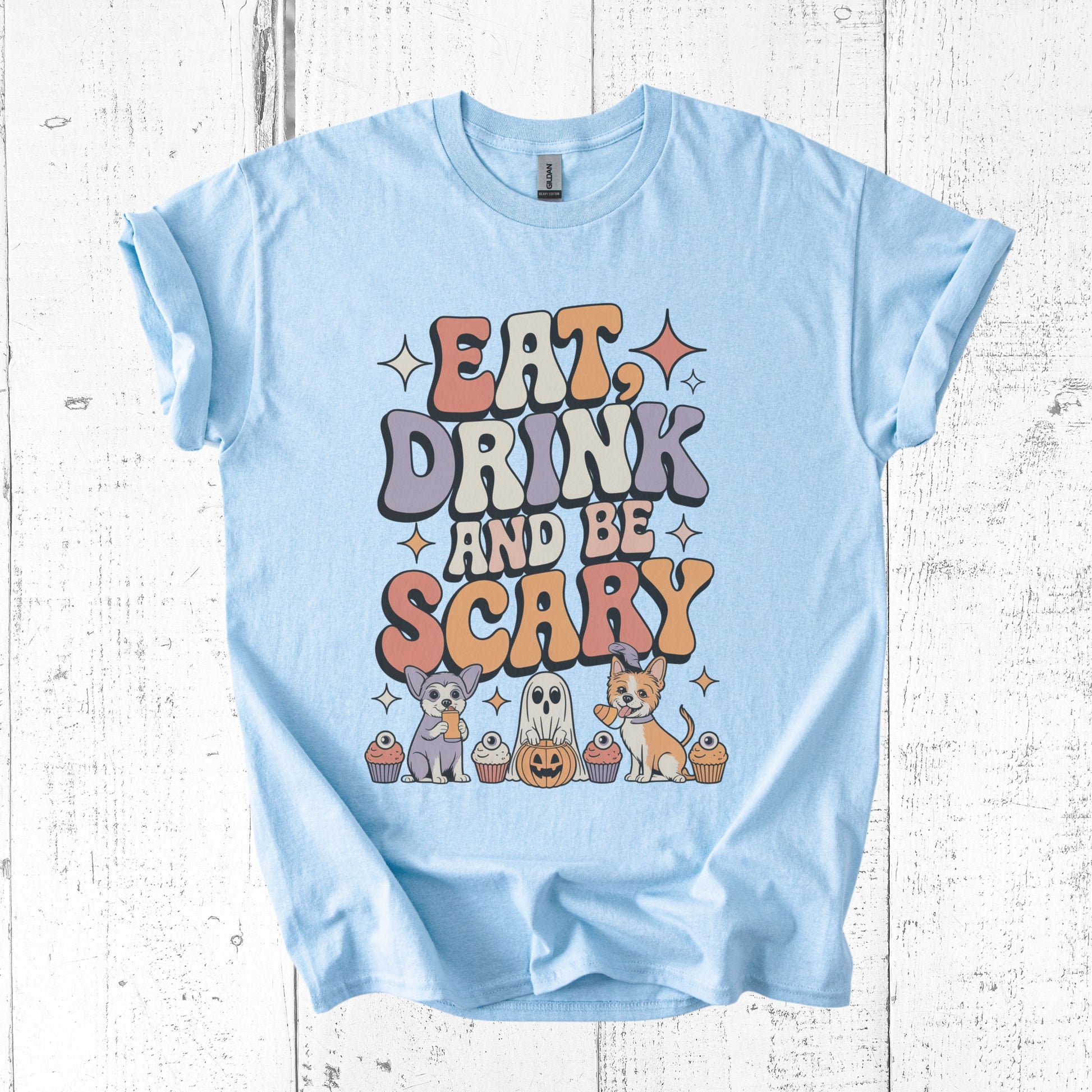 Light blue t-shirt with Halloween-themed design on a wooden surface