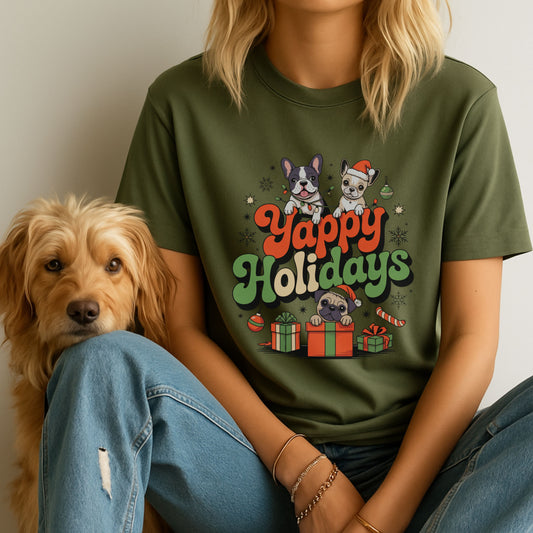 Person wearing a green t-shirt with 'Yappy Holidays' and dog graphics, sitting next to a dog.