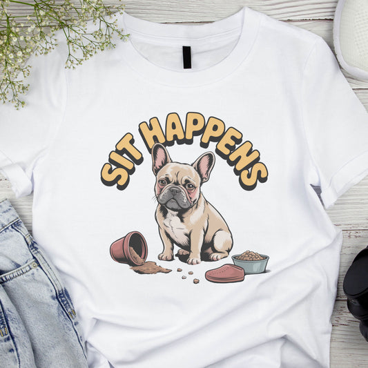 White t-shirt with a dog graphic and 'SIT HAPPENS' text on a wooden surface.