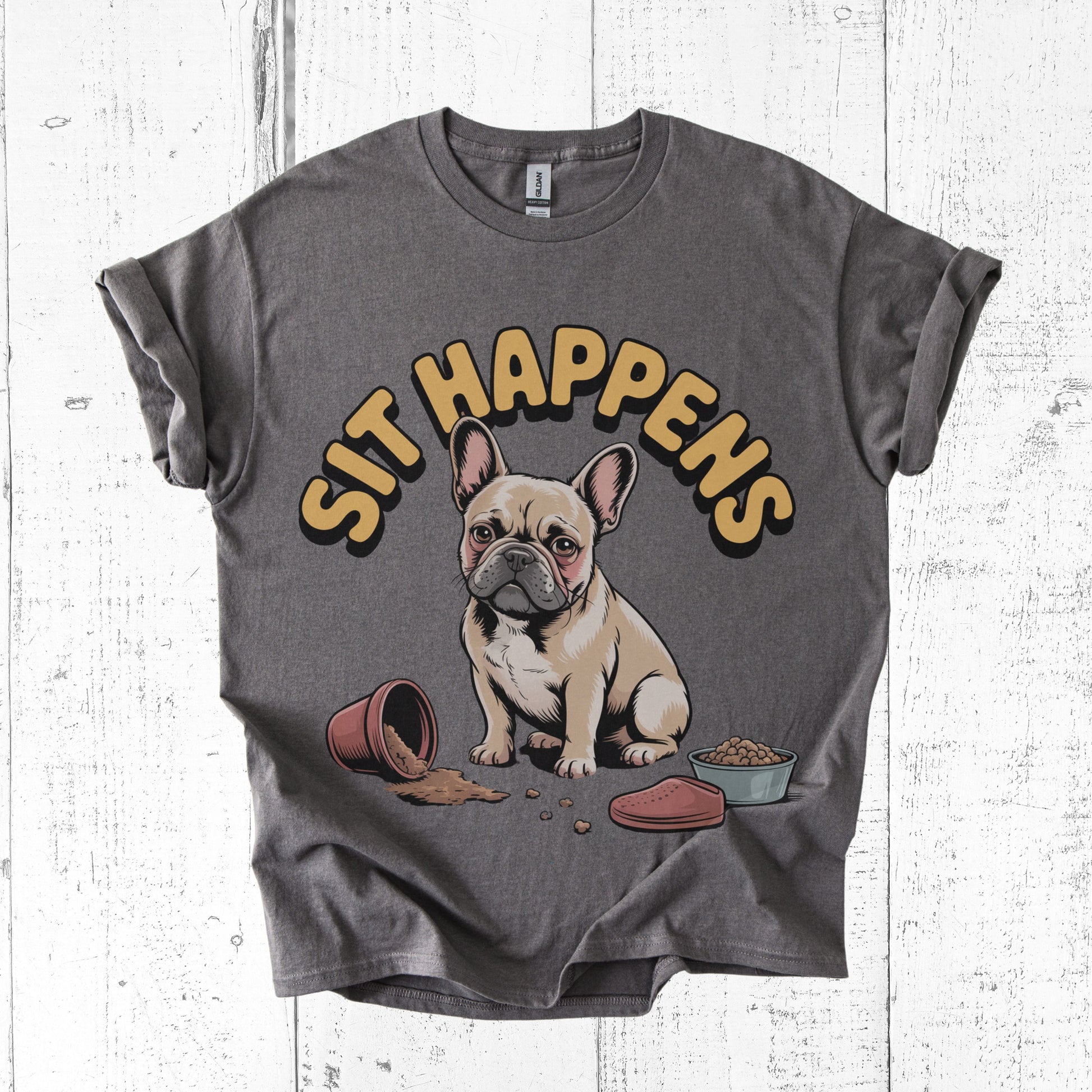 Gray t-shirt with a dog graphic and 'SIT HAPPENS' text on a white wooden surface