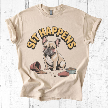 Beige t-shirt with a cartoon dog and 'Sit Happens' text on a white wooden background