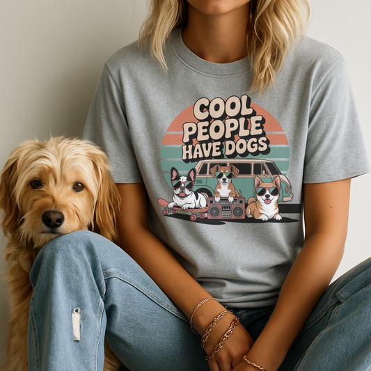 Person wearing a t-shirt with 'Cool people have dogs' graphic and a dog sitting next to them.