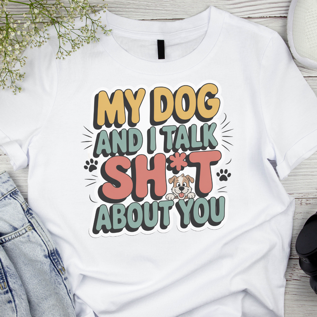 White t-shirt with humorous text design featuring a dog illustration on a wooden surface.