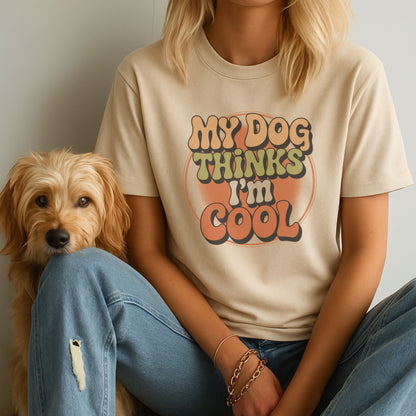 Person wearing a t-shirt with 'My dog thinks I'm cool' text sitting next to a dog.