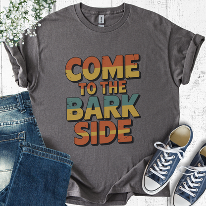 Gray t-shirt with 'Come to the Bark Side' text, paired with jeans and sneakers on a light wooden surface.