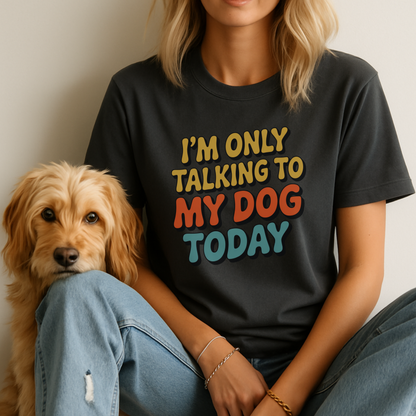 Person wearing a black t-shirt with colorful text sitting next to a dog.