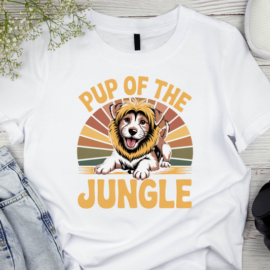 White t-shirt with a graphic of a dog wearing a lion mane and text 'Pup of the Jungle' on a wooden surface.