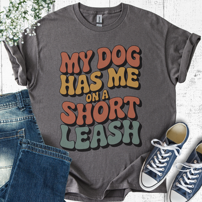 Gray t-shirt with colorful text 'My dog has me on a short leash' displayed with jeans and sneakers.