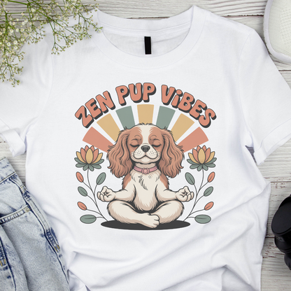 White t-shirt with a dog illustration and 'Zen Pup Vibes' text on a wooden surface.