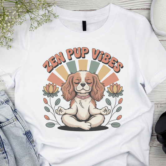 White t-shirt with a dog illustration and 'Zen Pup Vibes' text on a wooden surface.