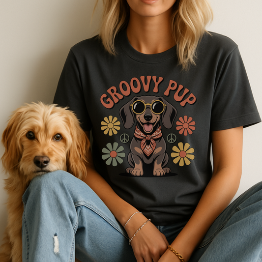 Person wearing a black t-shirt with 'Groovy Pup' design sitting next to a dog.