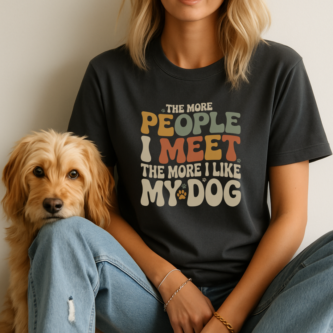 Person wearing a black t-shirt with a humorous dog-themed quote, sitting next to a dog.