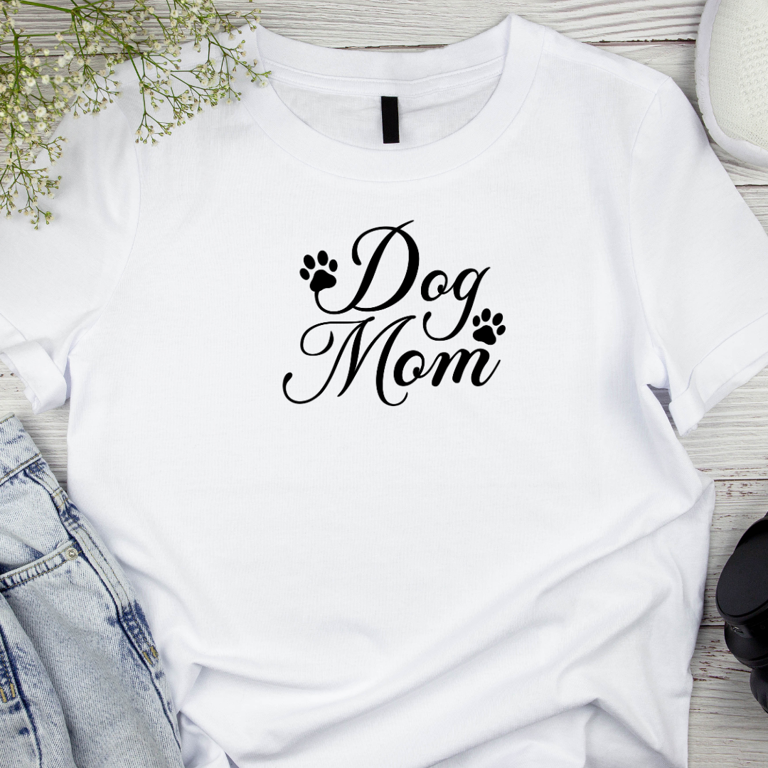 White t-shirt with 'Dog Mom' text on a wooden surface with denim jeans and baby's breath flowers.