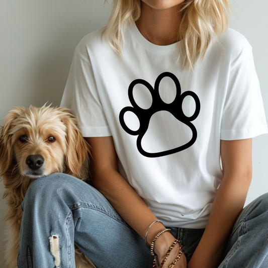 Person wearing a white t-shirt with a black paw print design, sitting next to a dog.