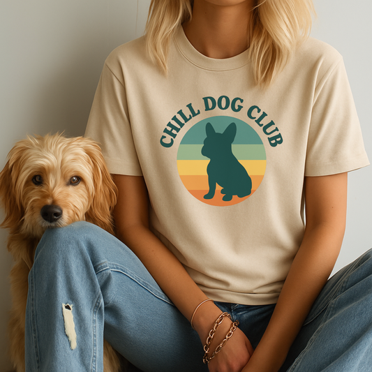 Person wearing a 'Chill Dog Club' t-shirt with a dog graphic, sitting next to a small dog.