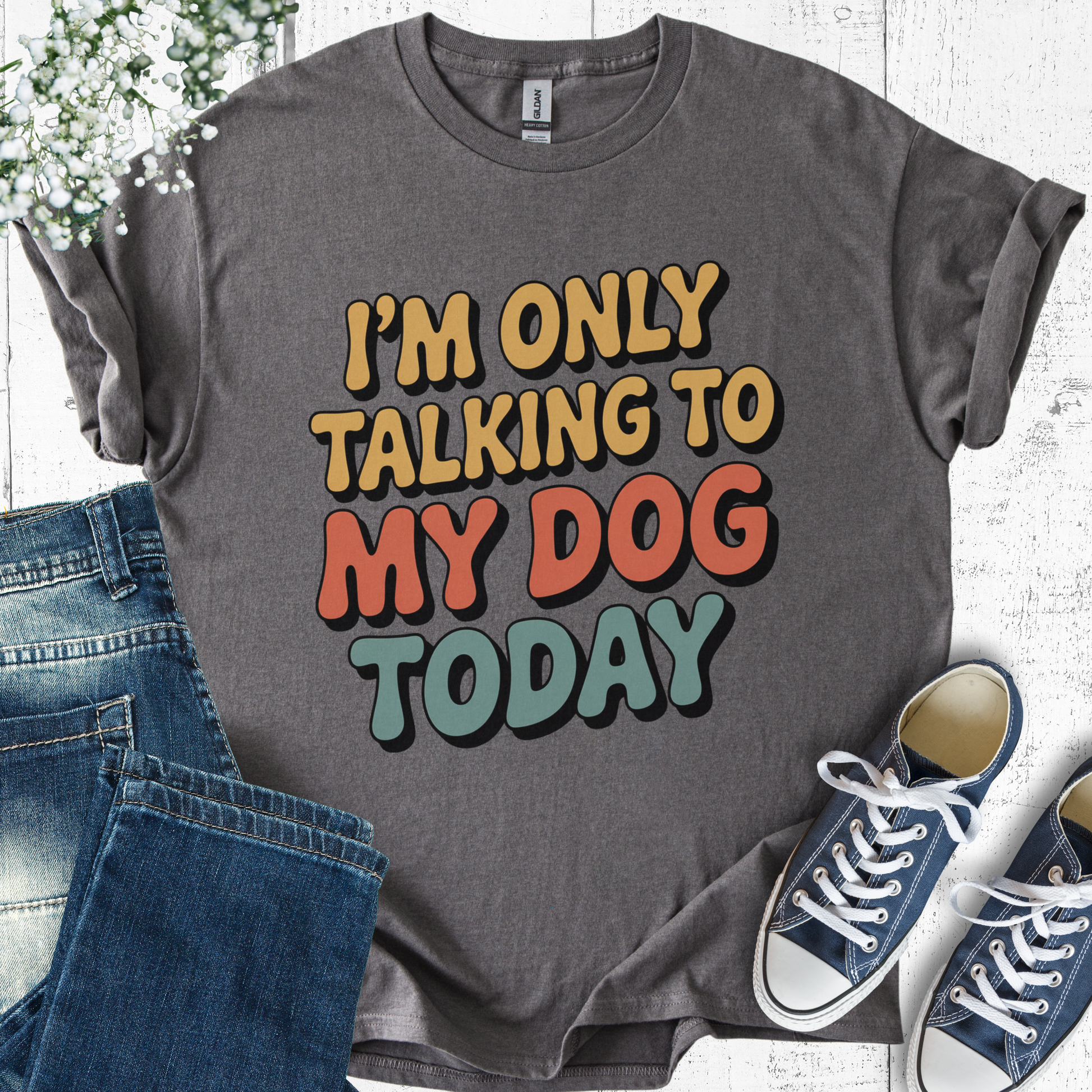 Gray t-shirt with colorful text 'I'm only talking to my dog today' on a white background with jeans and sneakers.