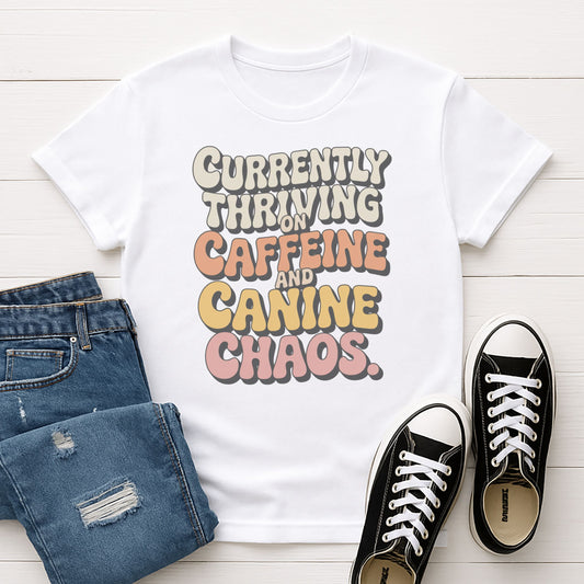 White Gildan 6400 unisex t-shirt with retro dog graphic and ‘Currently Thriving On Caffeine And Canine Chaos’ text, perfect for dog lovers.