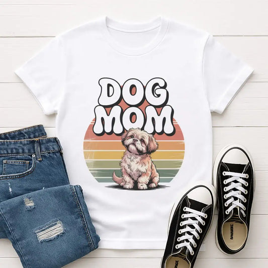 White t-shirt with 'DOG MOM' and dog graphic, paired with jeans and black sneakers on a light wooden floor.